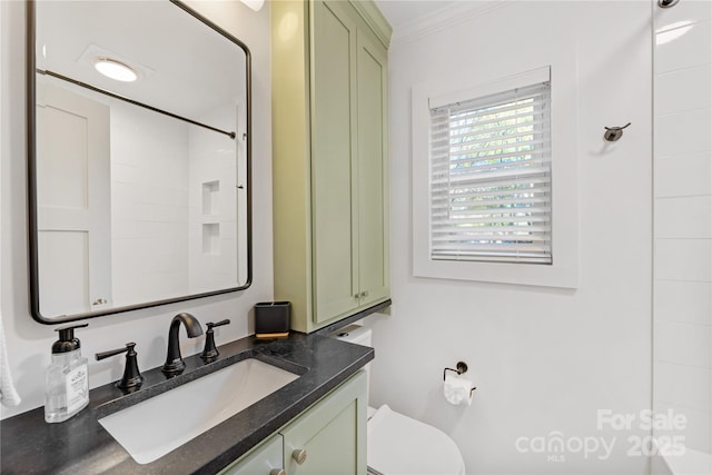 bathroom featuring ornamental molding, vanity, and toilet