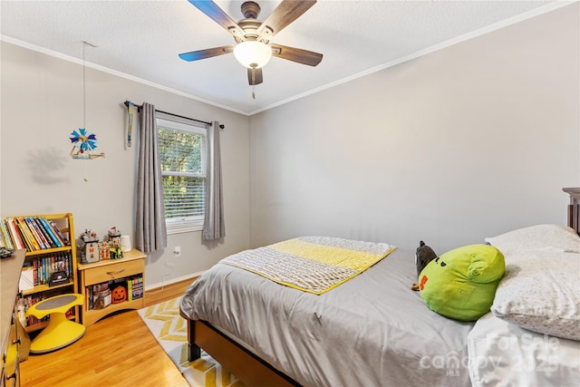 bedroom with a textured ceiling, ceiling fan, wood finished floors, and crown molding