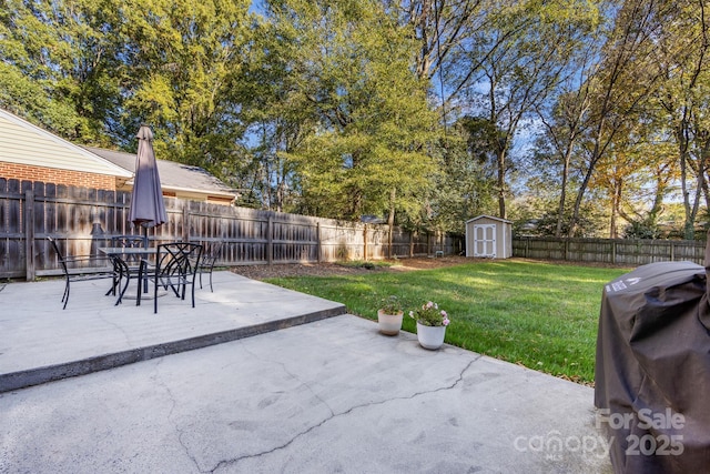 view of patio featuring a fenced backyard, a storage unit, grilling area, and an outbuilding