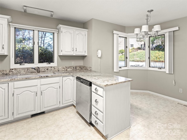 kitchen featuring a peninsula, a sink, visible vents, stainless steel dishwasher, and light floors