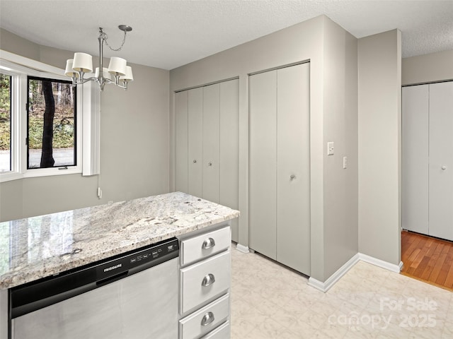 kitchen featuring decorative light fixtures, a notable chandelier, a textured ceiling, light stone countertops, and dishwasher