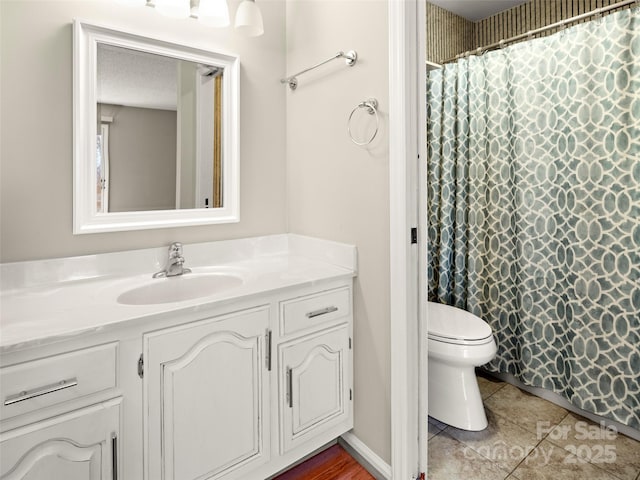 bathroom with curtained shower, vanity, toilet, and tile patterned floors