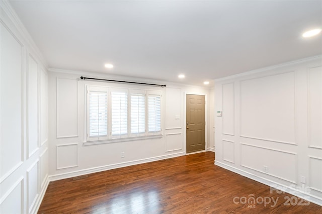 unfurnished room with recessed lighting, a decorative wall, and wood finished floors