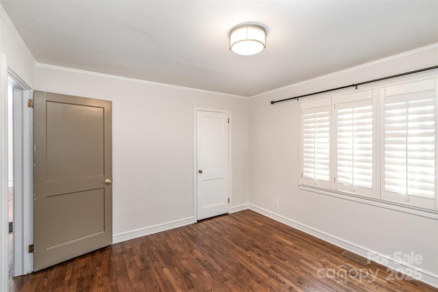 unfurnished bedroom with baseboards, visible vents, ornamental molding, and wood finished floors