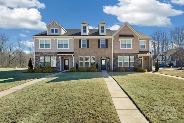 townhome / multi-family property featuring a front lawn and brick siding