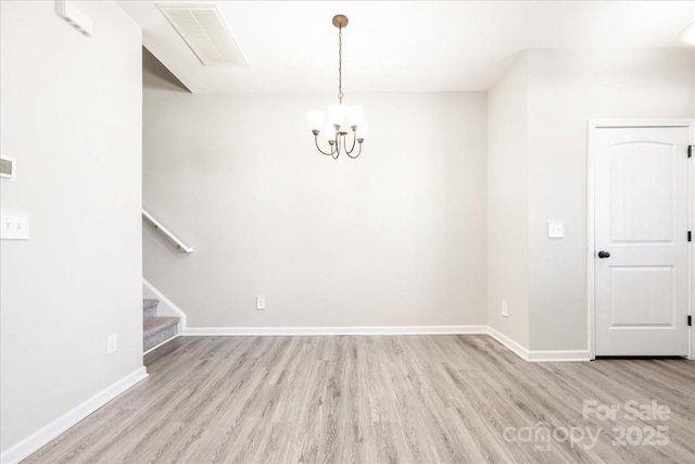 unfurnished dining area featuring visible vents, an inviting chandelier, wood finished floors, baseboards, and stairs