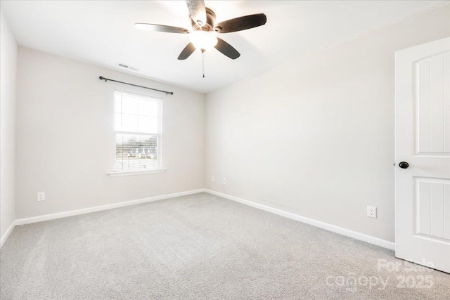 carpeted empty room featuring baseboards, visible vents, and a ceiling fan