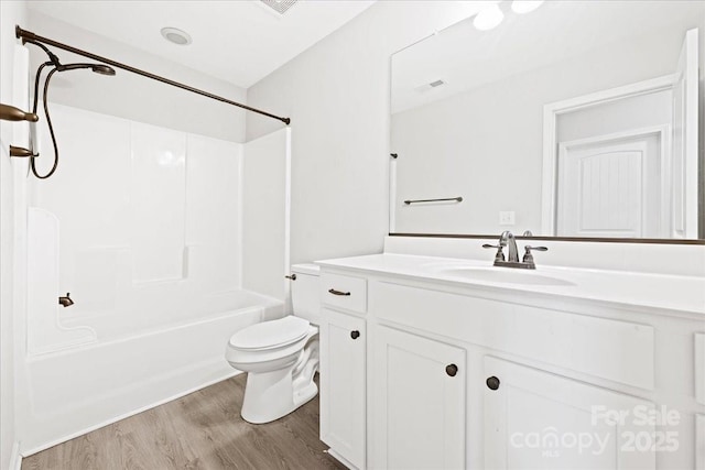 full bathroom featuring bathtub / shower combination, toilet, wood finished floors, visible vents, and vanity