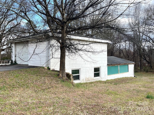 view of home's exterior with a yard and a detached garage