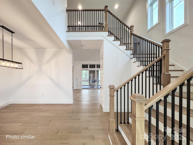 entryway featuring a high ceiling, baseboards, and wood finished floors