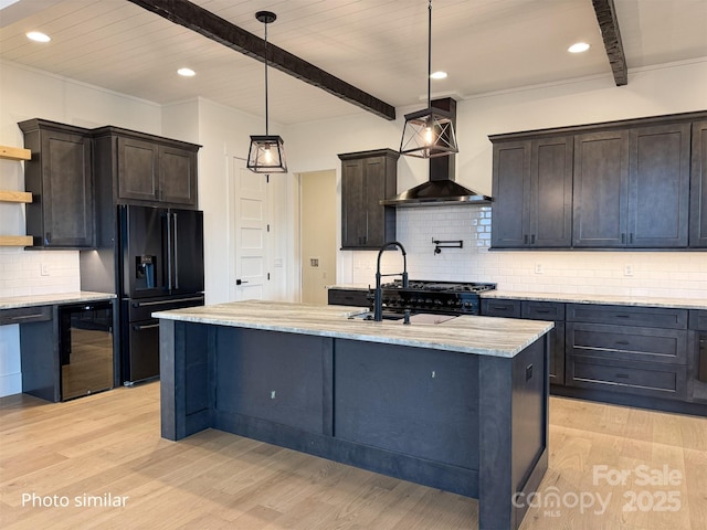 kitchen featuring wall chimney exhaust hood, wine cooler, black fridge, open shelves, and beam ceiling