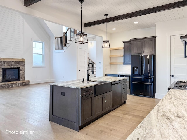 kitchen featuring dishwashing machine, a sink, black fridge with ice dispenser, beam ceiling, and tasteful backsplash