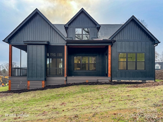 back of property with a sunroom, crawl space, roof with shingles, and a yard