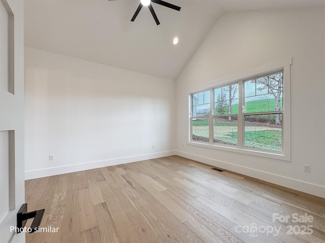 spare room with light wood-style floors, visible vents, high vaulted ceiling, and baseboards