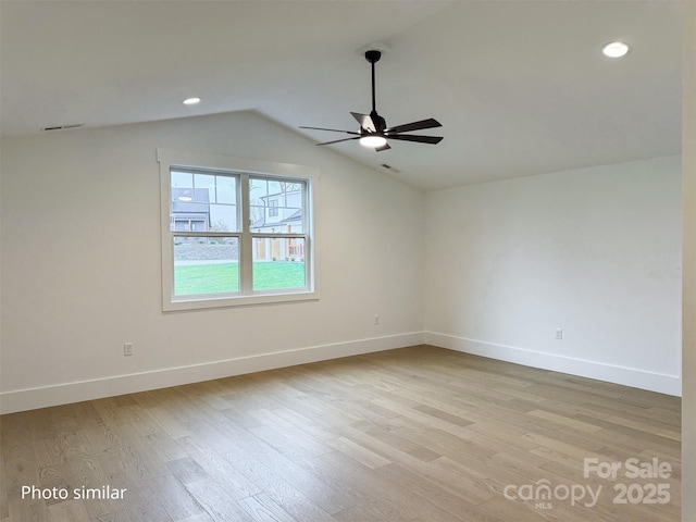 empty room featuring vaulted ceiling, ceiling fan, light wood-type flooring, and baseboards