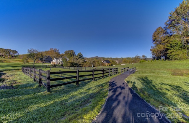 exterior space with a rural view, a lawn, and fence