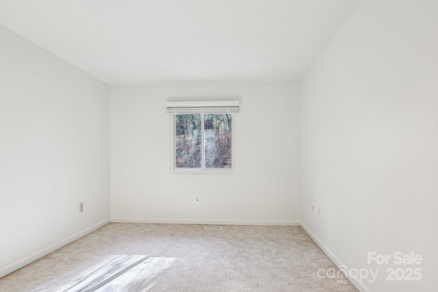 carpeted spare room featuring baseboards