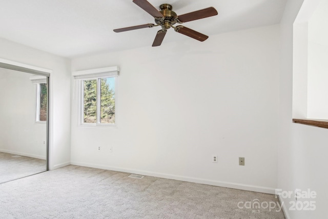 unfurnished bedroom featuring baseboards, visible vents, light carpet, and a closet