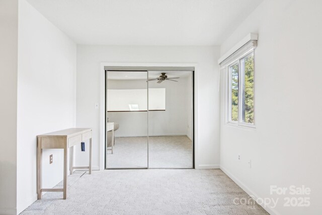 unfurnished bedroom with a closet, baseboards, and carpet flooring