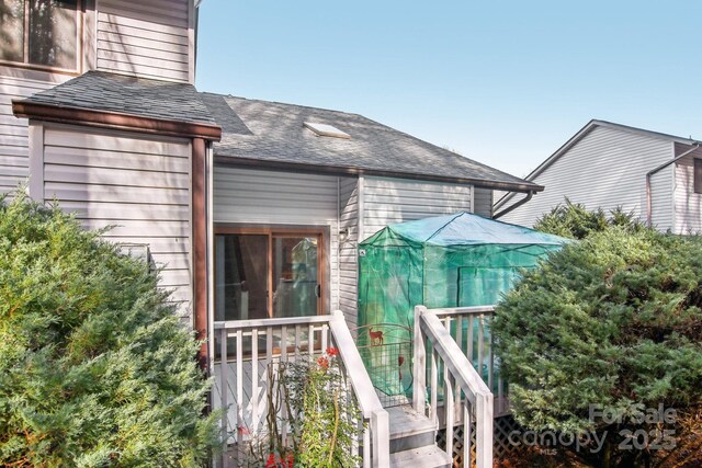 back of property featuring a shingled roof