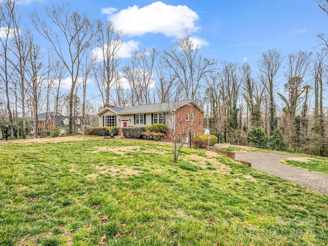 view of front of house featuring brick siding and a front yard