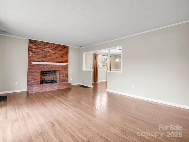 unfurnished living room featuring baseboards, crown molding, wood finished floors, and a brick fireplace