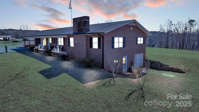 6285 NC-16 Hwy N, Taylorsville, NC 28681 - back of property at dusk featuring a yard, brick siding, a chimney, and a patio area