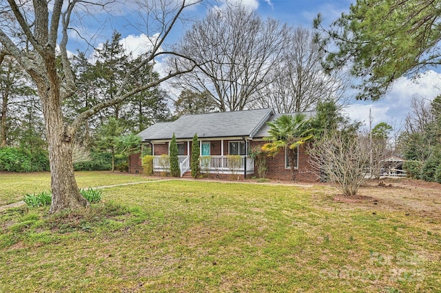 ranch-style home featuring covered porch, brick siding, and a front yard