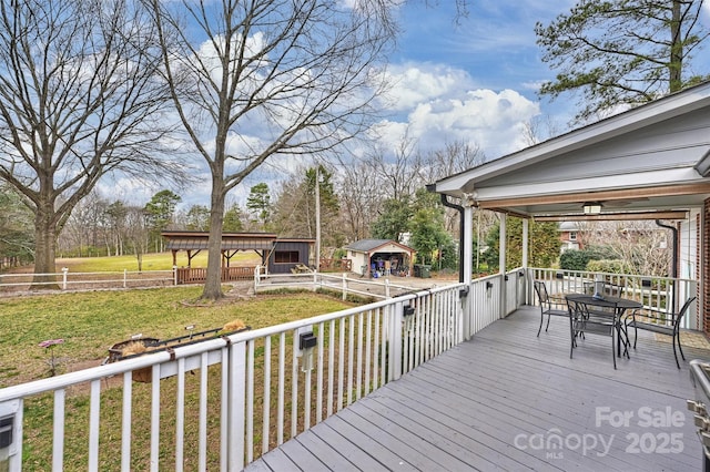 wooden deck with outdoor dining area and an outdoor structure