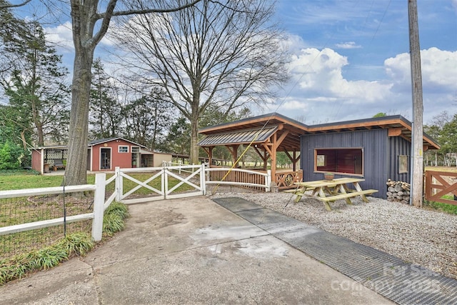 exterior space with an outbuilding, a gazebo, fence, and a gate