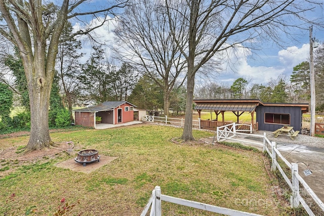 view of yard featuring a fire pit and an outdoor structure