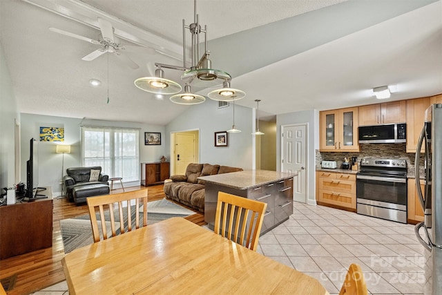 dining room with vaulted ceiling with beams, light tile patterned floors, ceiling fan, and visible vents