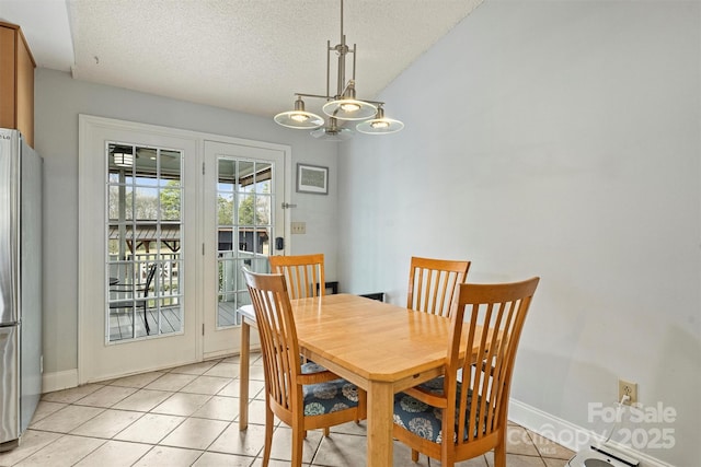 dining area with a chandelier, a textured ceiling, baseboards, and light tile patterned floors