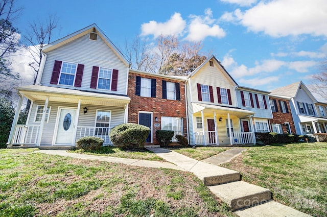 multi unit property featuring a porch and a front yard