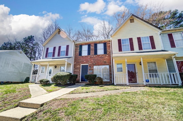 view of property featuring a porch and a front lawn