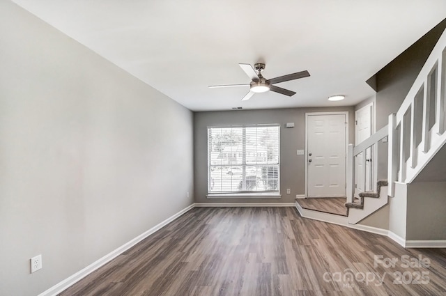 foyer entrance featuring a ceiling fan, wood finished floors, baseboards, and stairs