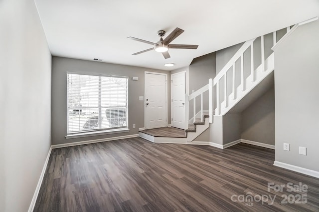 entrance foyer featuring dark wood-style flooring, a ceiling fan, visible vents, baseboards, and stairway