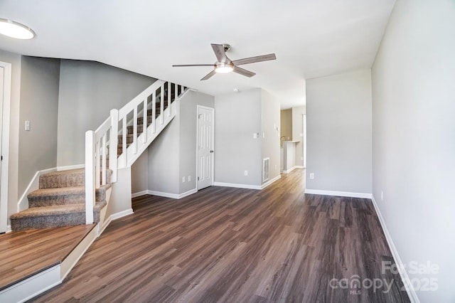 interior space featuring wood finished floors, visible vents, baseboards, and stairs