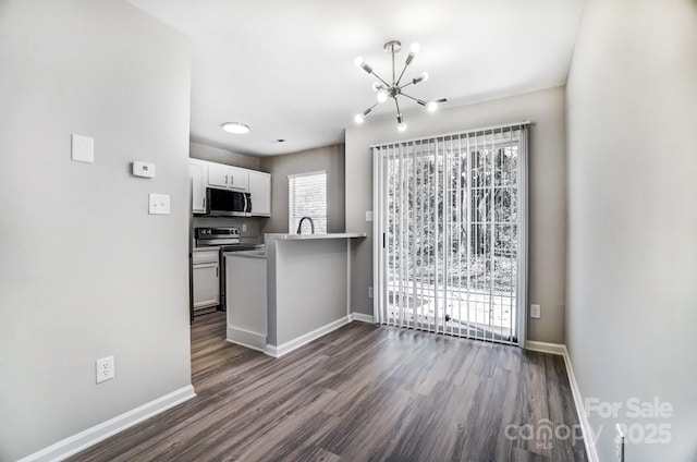 kitchen with appliances with stainless steel finishes, dark wood finished floors, and baseboards