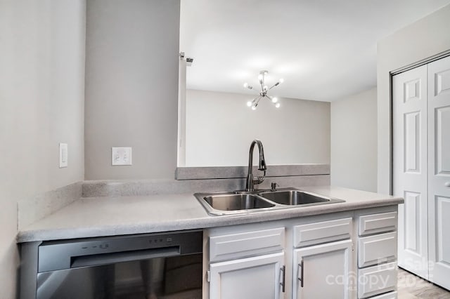 kitchen with a sink, white cabinets, light countertops, and dishwasher