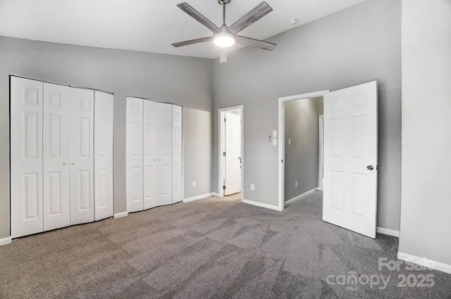 unfurnished bedroom featuring carpet, vaulted ceiling, baseboards, and two closets