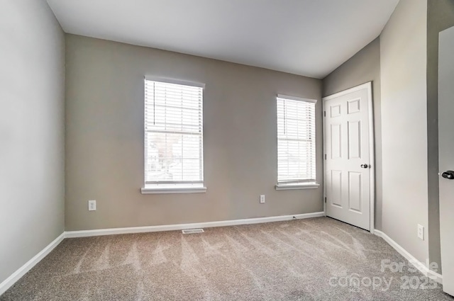 empty room featuring plenty of natural light, baseboards, and carpet flooring