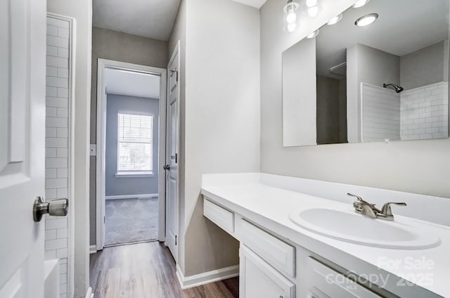 full bath featuring vanity, baseboards, and wood finished floors