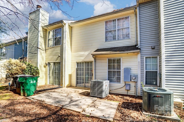 back of house with a patio, a chimney, and central AC unit