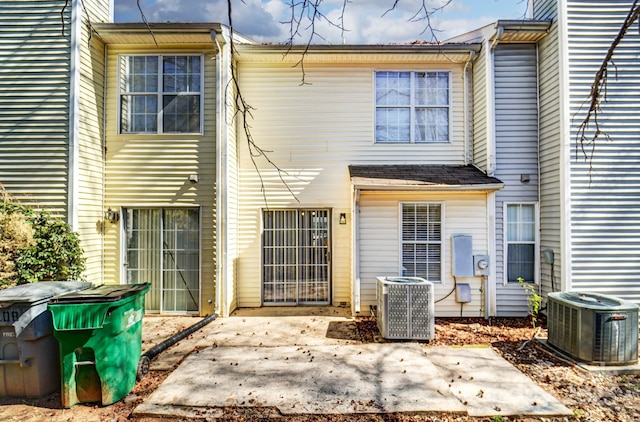 back of property with central AC and a patio