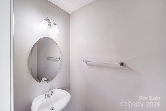 bathroom featuring a sink and a textured ceiling