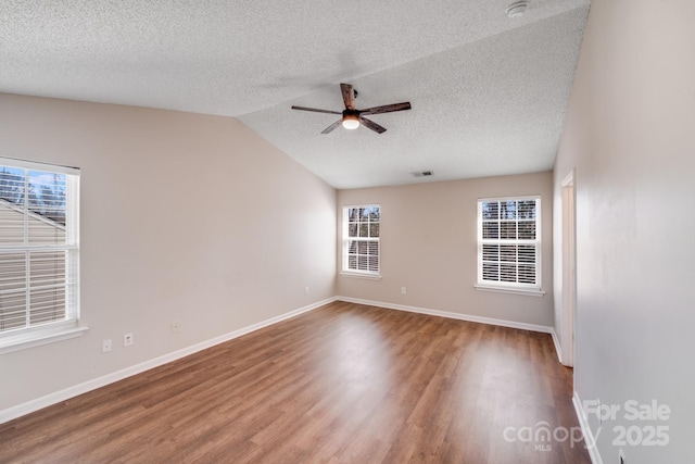 spare room with vaulted ceiling, baseboards, ceiling fan, and wood finished floors