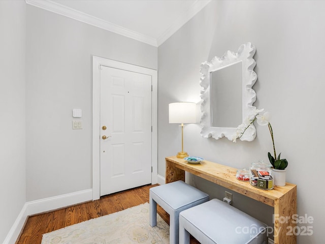 entrance foyer with crown molding, baseboards, and wood finished floors