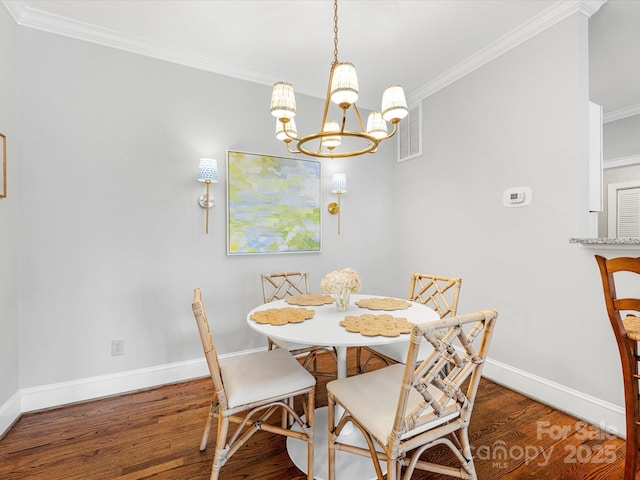 dining room featuring visible vents, crown molding, and wood finished floors