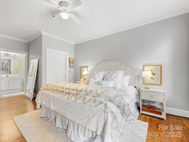 bedroom featuring ceiling fan, wood finished floors, baseboards, ornamental molding, and ensuite bath